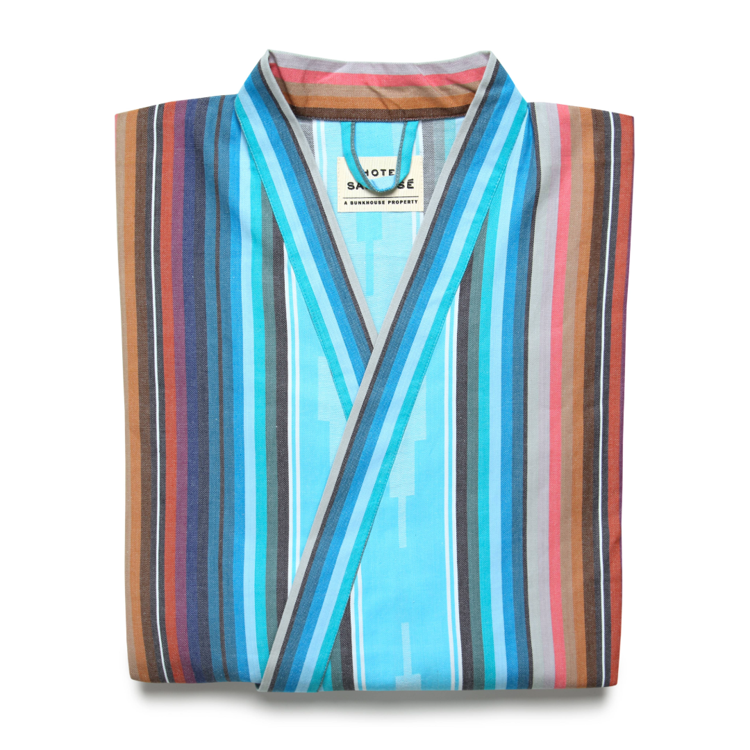 A folded multicolored striped kimono robe against a white backdrop.