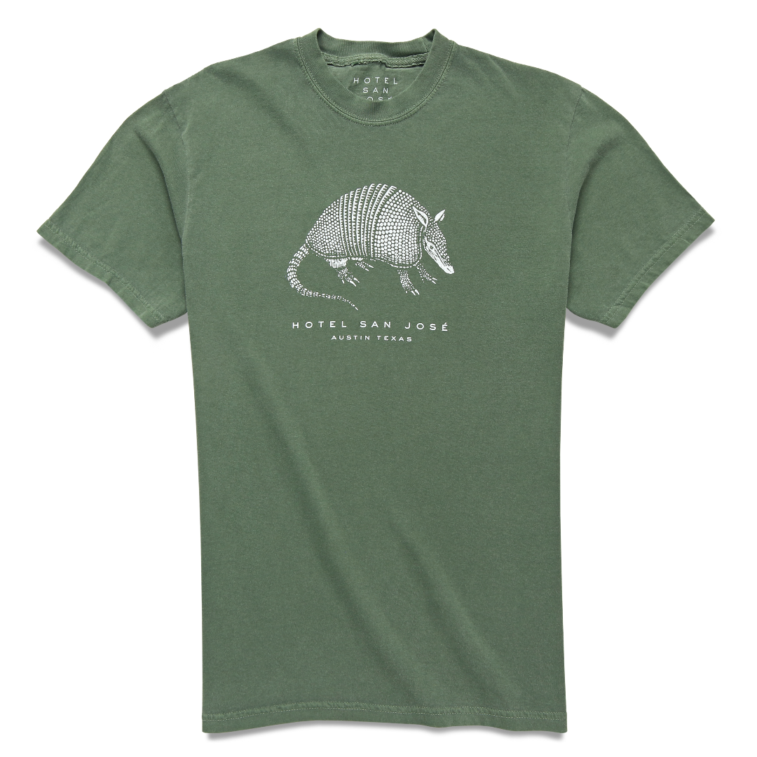 A green unisex crew neck t-shirt with a white printed armadillo design and text 'HOTEL SAN JOSE AUSTIN TEXAS' on the front.
