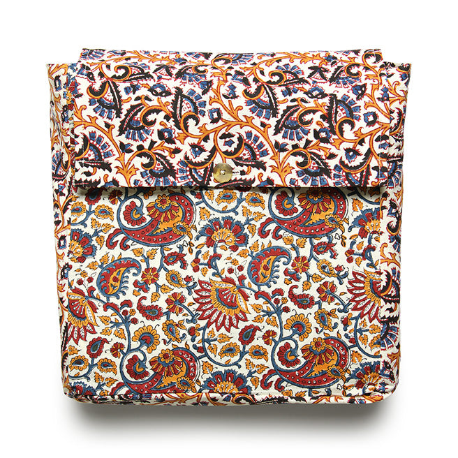 A folded reversible duvet cover with a floral and paisley pattern in multiple colors including orange, blue, green, and brown on a white background.