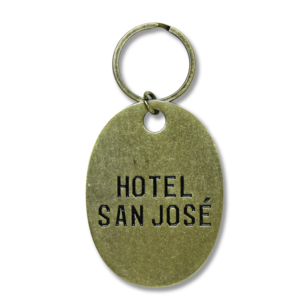 A brass keychain with 'HOTEL SAN JOSE' stamped on it.
