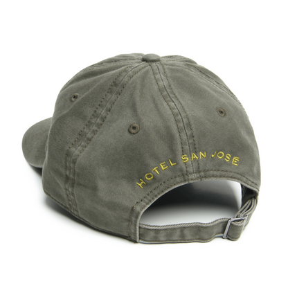 An olive green 'dad hat' with light green embroidery text 'HOTEL SAN JOSE', featuring an adjustable fabric back strap with a brass buckle.