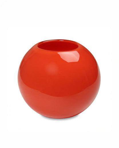 Glossy red spherical vase on a white background