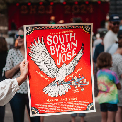 A colorful poster featuring a bird with spread wings, text celebrating the 25th Anniversary of South By San Jose, and a list of musicians being held by a person with a crowd and stage behind it.