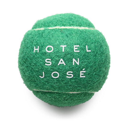 A green tennis ball with the text 'HOTEL SAN JOSÉ' printed on it.