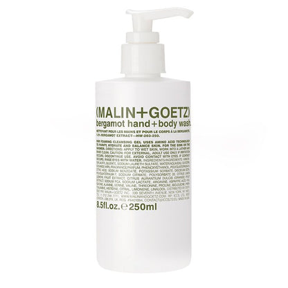 A white pump bottle labeled 'MALIN+GOETZ bergamot hand + body wash' with product details in black text.
