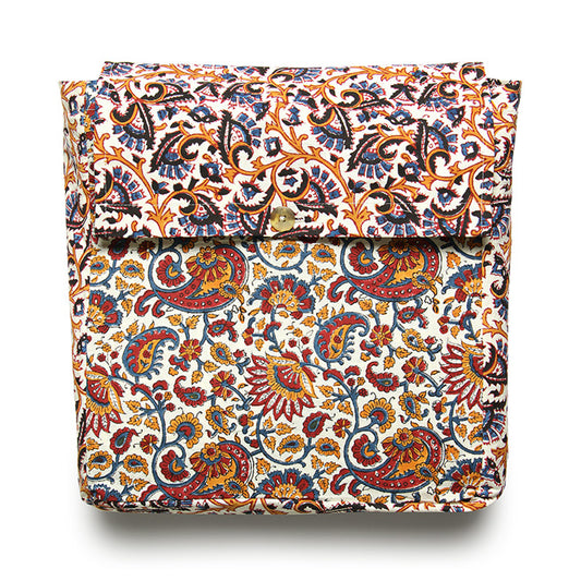 A folded reversible duvet cover with a floral and paisley pattern in multiple colors including orange, blue, green, and brown on a white background.