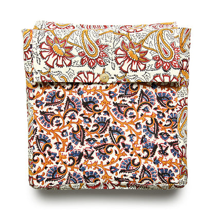 A folded reversible duvet cover with a floral pattern featuring a mix of orange, red, and blue colors on a white background.