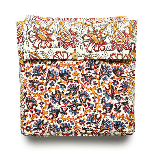 A folded reversible duvet cover with a floral pattern featuring a mix of orange, red, and blue colors on a white background.
