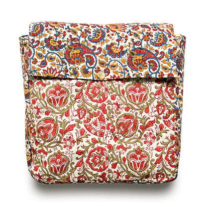 A folded reversible duvet cover with a floral pattern in shades of red, green, and white.