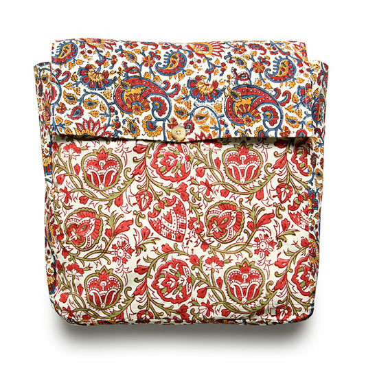 A folded reversible duvet cover with a floral pattern in shades of red, green, and white.